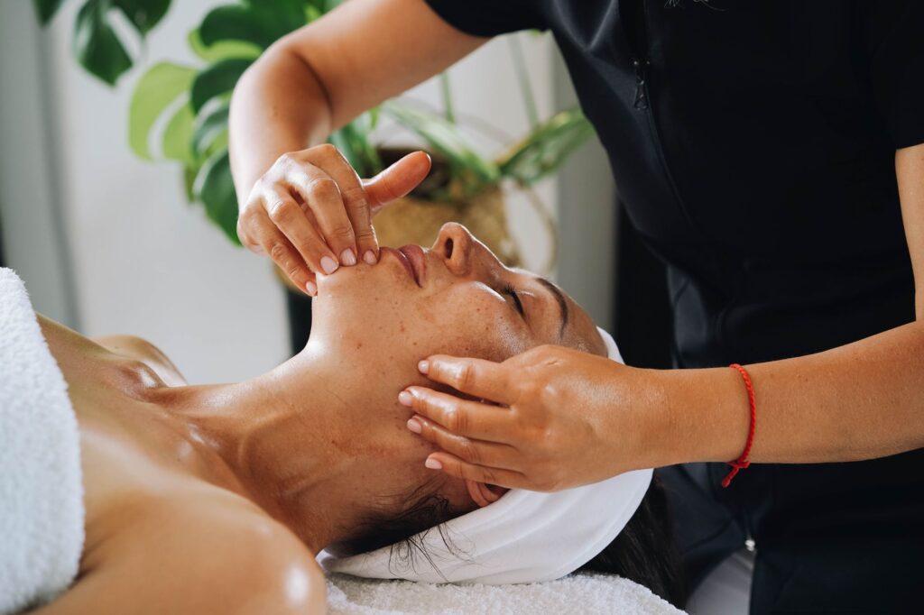 Therapist performing facial treatment on client in spa setting